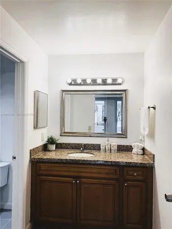 a sink with a granite countertop double vanity and a mirror
