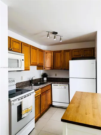 a kitchen with a stove a sink and white cabinets