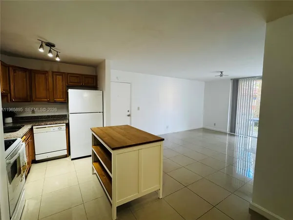 a kitchen with a refrigerator and a stove top oven