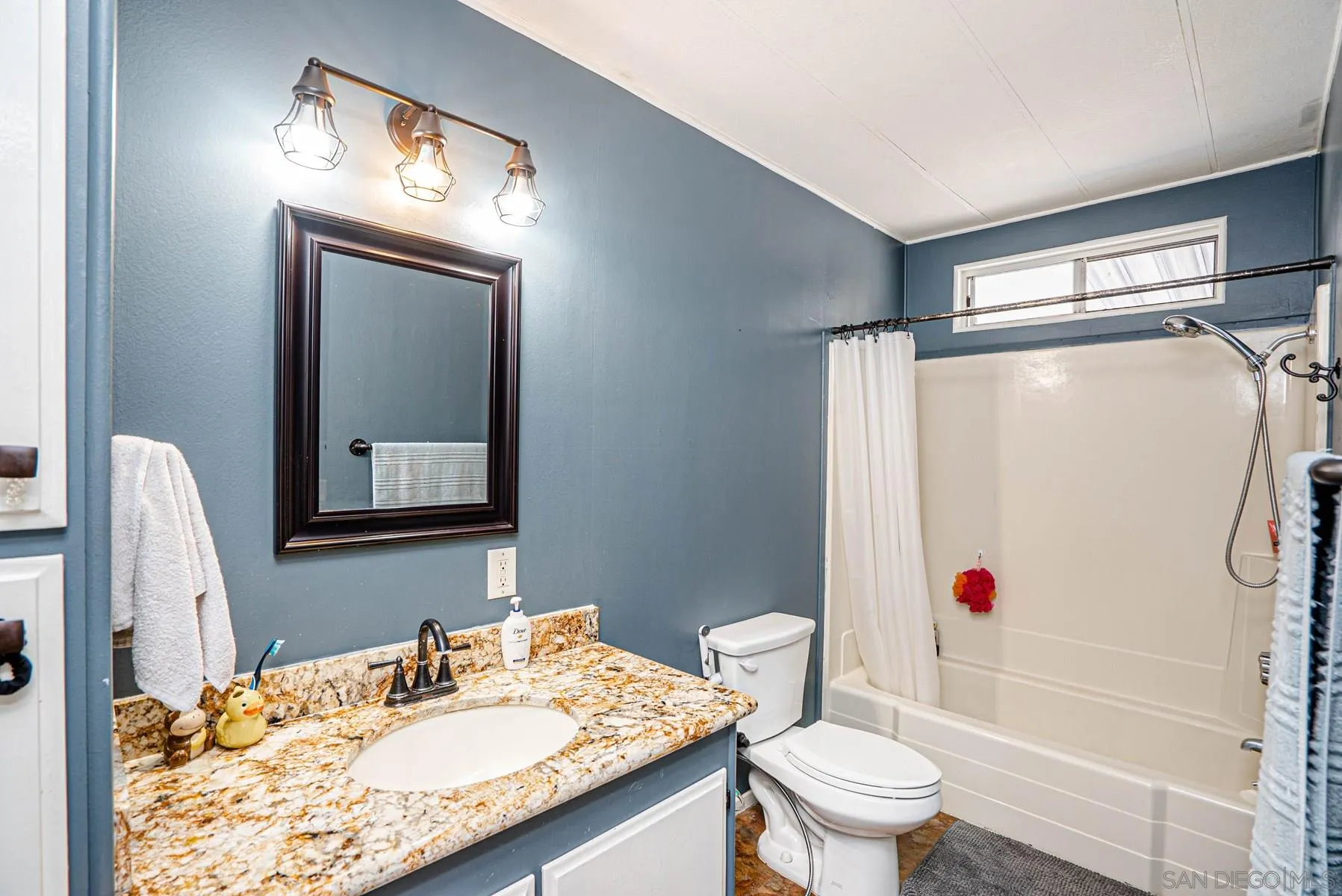 10880 Highway 67, Unit 17 Lakeside, CA 92040 - Photo 16 of 20 a bathroom with a sink vanity mirror and toilet