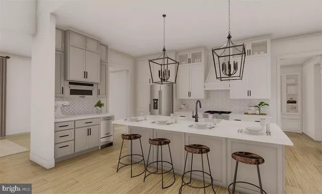 a kitchen with stainless steel appliances white cabinets and a wooden floor