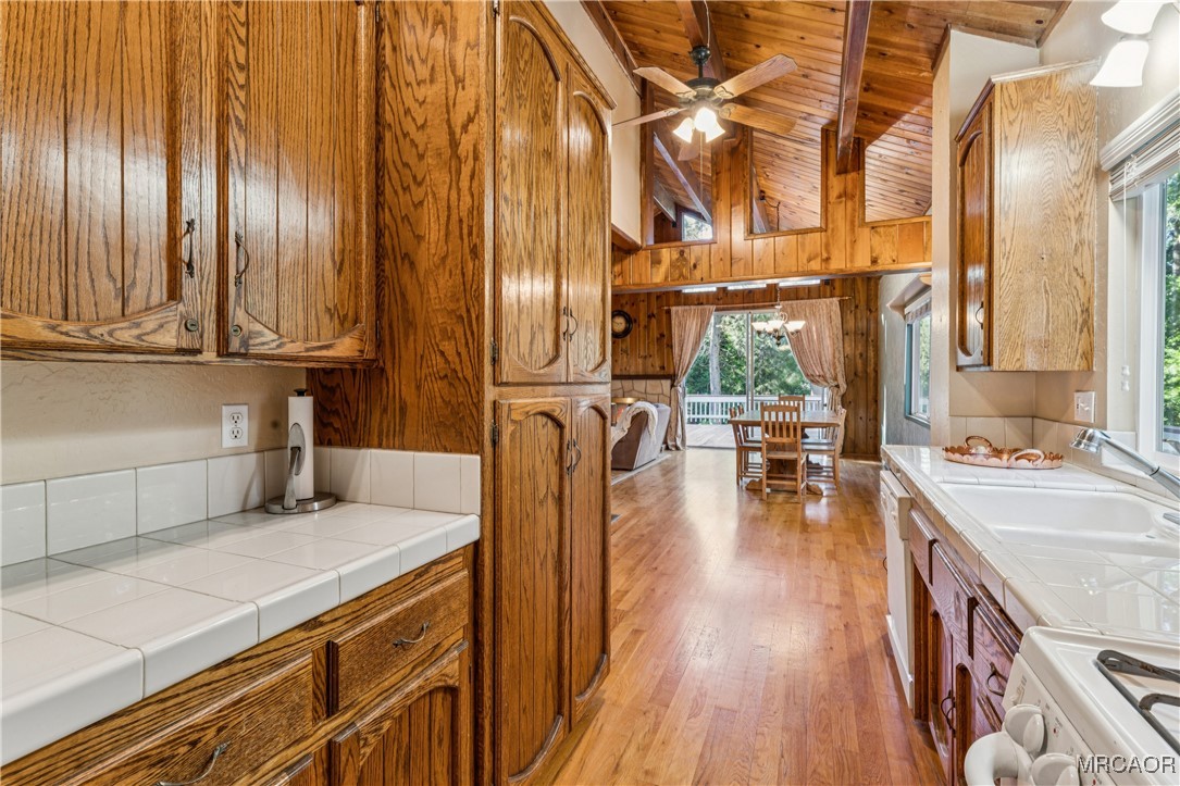 296 Massive Road Lake Arrowhead, CA 92352 - Photo 12 of 43 a kitchen with stainless steel appliances granite countertop a lot of counter space and wooden floors