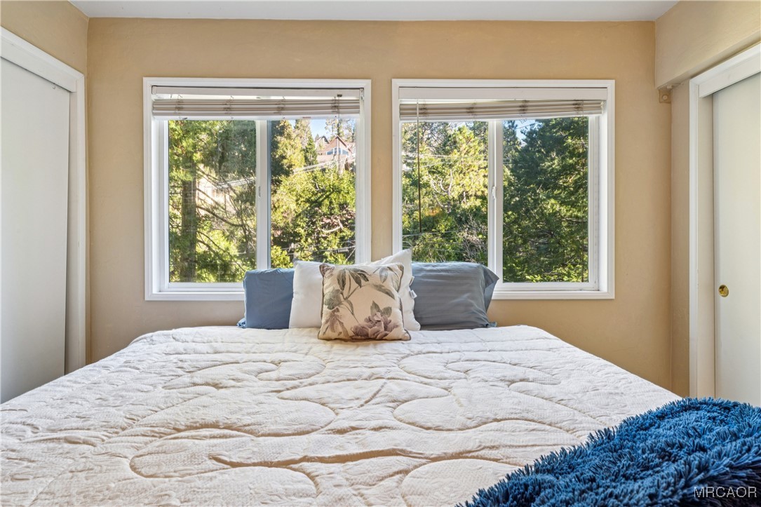 296 Massive Road Lake Arrowhead, CA 92352 - Photo 18 of 43 a bedroom with a large bed and a window