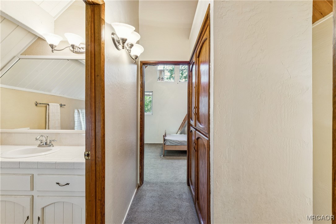 296 Massive Road Lake Arrowhead, CA 92352 - Photo 22 of 43 a en suite bathroom with a sink a mirror and a shower