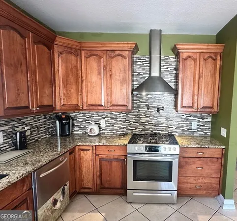 a kitchen with granite countertop a stove top oven microwave and cabinets