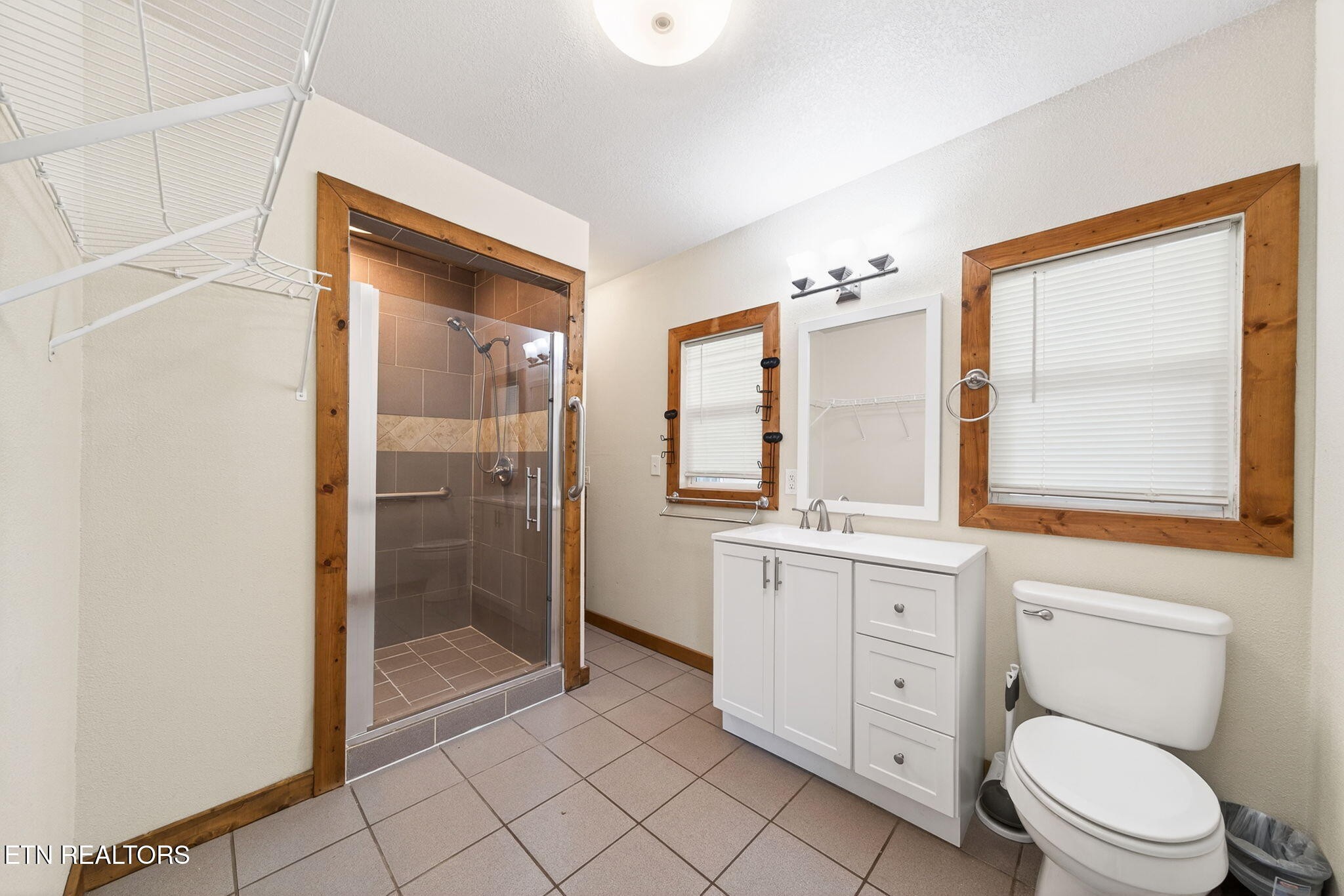 935 Brewer Road Crossville, TN 38572 - Photo 23 of 51 a bathroom with a toilet a sink a mirror a shower a window and vanity