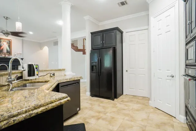 a kitchen with stainless steel appliances granite countertop a refrigerator a sink and a stove