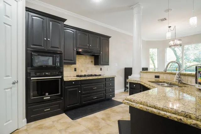 a kitchen with stainless steel appliances granite countertop a stove and cabinets