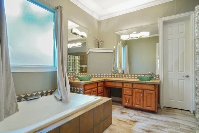 a bathroom with a tub sink and mirror