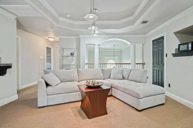 a living room with furniture and a view of kitchen