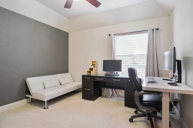 a view of a workspace with furniture and a window