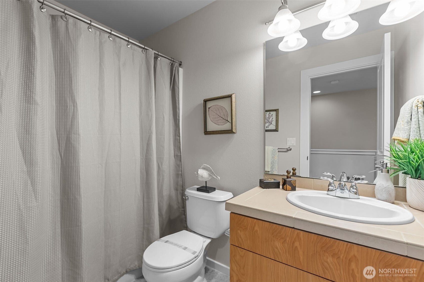 67 Cougar Ridge Road Northwest, Unit 2013 Issaquah, WA 98027 - Photo 20 of 33 a bathroom with a sink a toilet a mirror and shower curtain