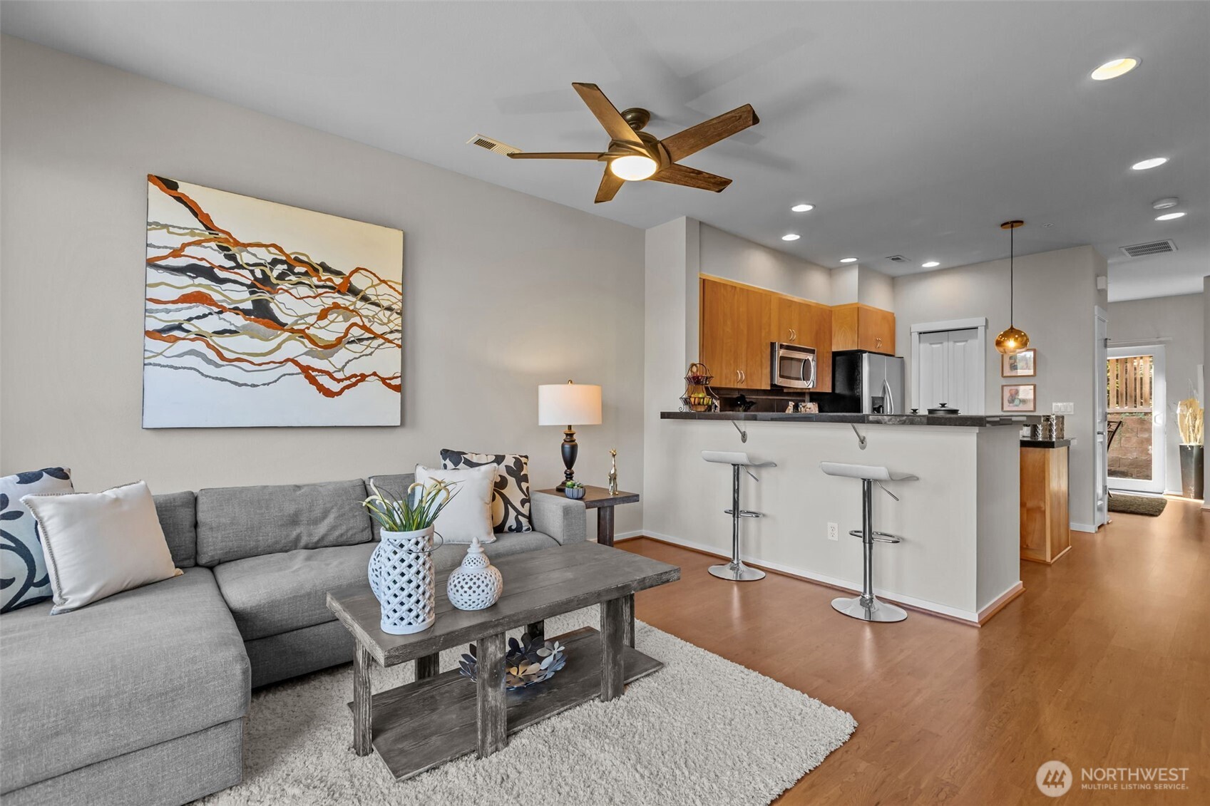 67 Cougar Ridge Road Northwest, Unit 2013 Issaquah, WA 98027 - Photo 4 of 33 a living room with furniture kitchen view and a wooden floor