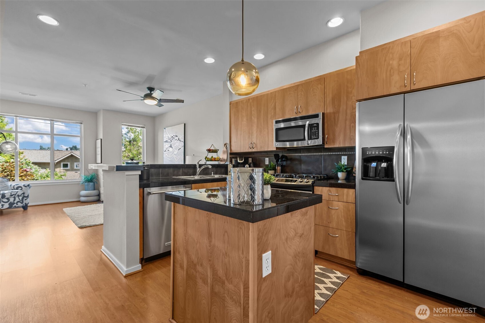 67 Cougar Ridge Road Northwest, Unit 2013 Issaquah, WA 98027 - Photo 7 of 33 a kitchen with stainless steel appliances granite countertop a refrigerator a stove a sink dishwasher a refrigerator and a dining table with wooden floor