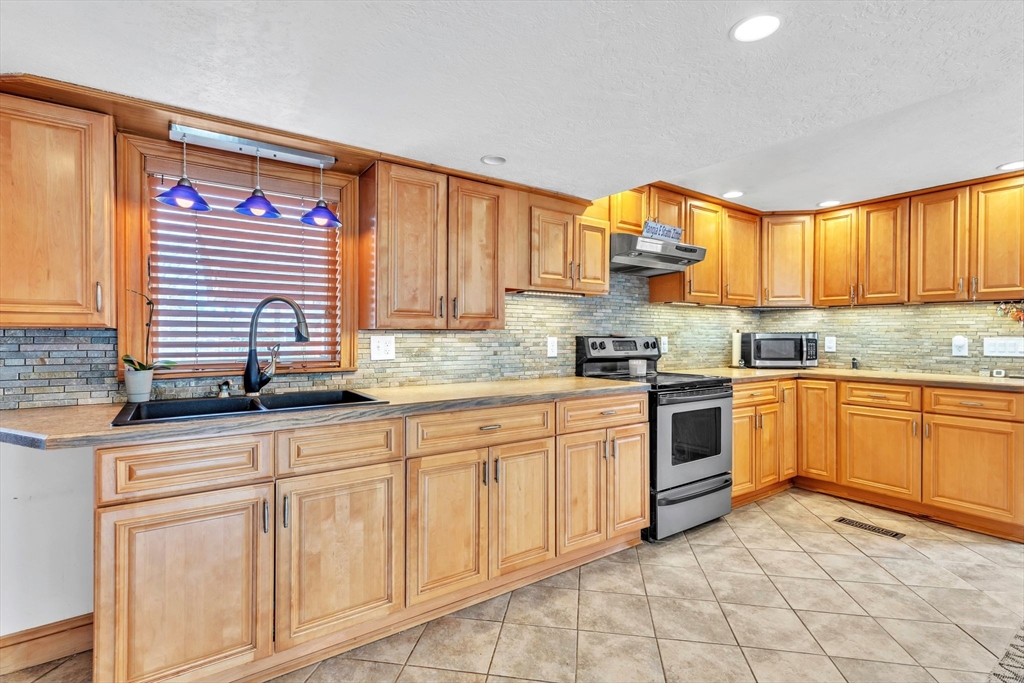 6 Babb Road Southwick, MA 01077 - Photo 21 of 42 a kitchen with granite countertop a stove sink and cabinets
