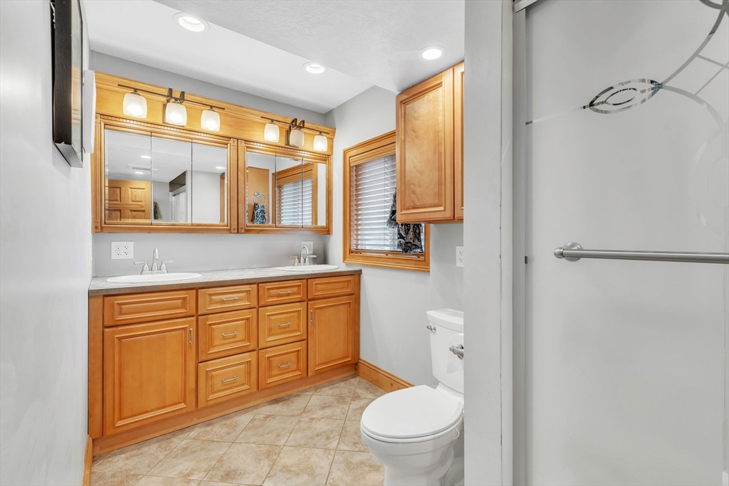 6 Babb Road Southwick, MA 01077 - Photo 31 of 42 a bathroom with a granite countertop toilet sink and mirror next to a window