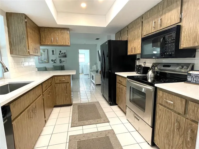 a kitchen with stainless steel appliances granite countertop a stove a sink dishwasher and a refrigerator