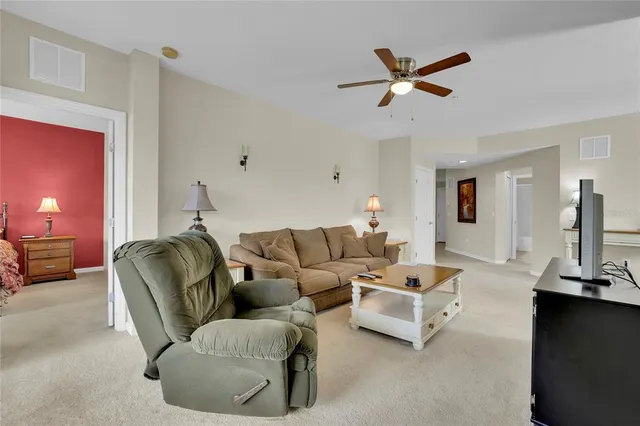 a living room with furniture and a ceiling fan
