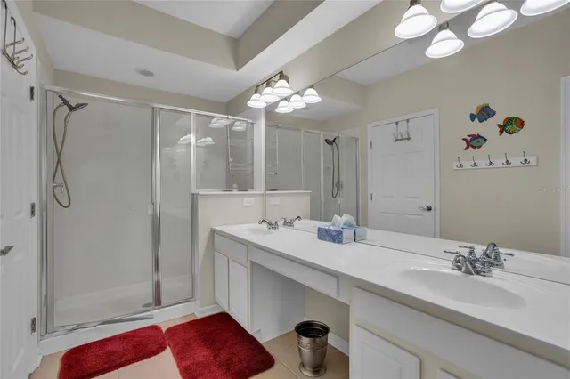 a bathroom with a double vanity sink mirror and shower