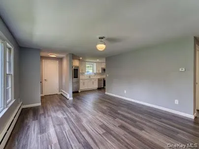 a view of a livingroom with wooden floor and window