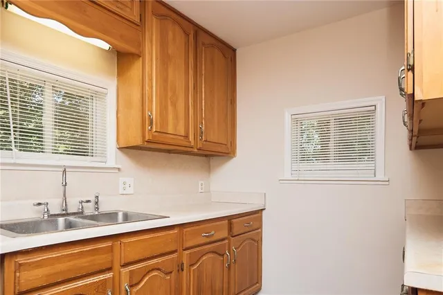 a kitchen with stainless steel appliances granite countertop a sink and cabinets next to a window