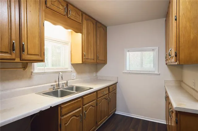 a kitchen with a sink cabinets appliances and a window
