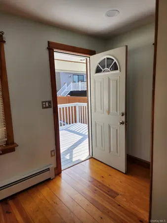 a view of a hallway with wooden floor and door