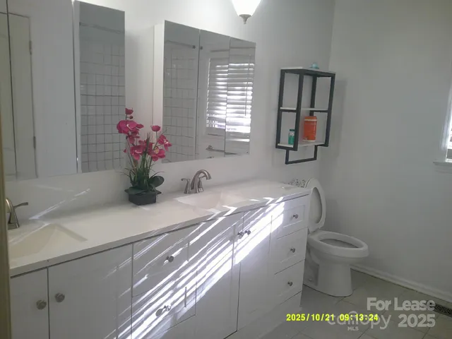 a bathroom with a sink toilet and window