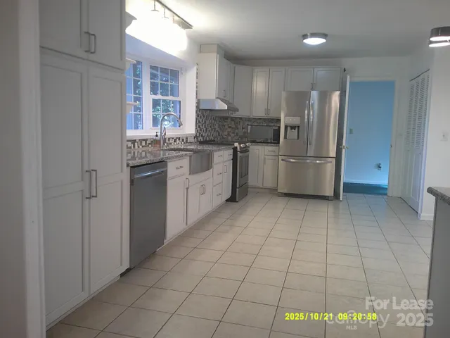 a kitchen with stainless steel appliances granite countertop a refrigerator and a stove top oven