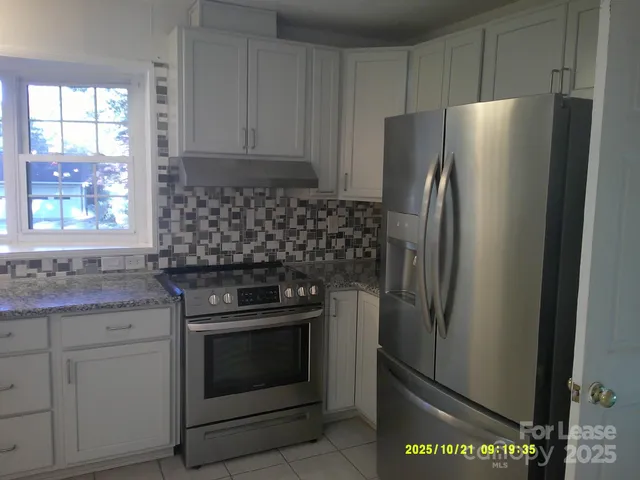 a kitchen with stainless steel appliances granite countertop a refrigerator sink and stove