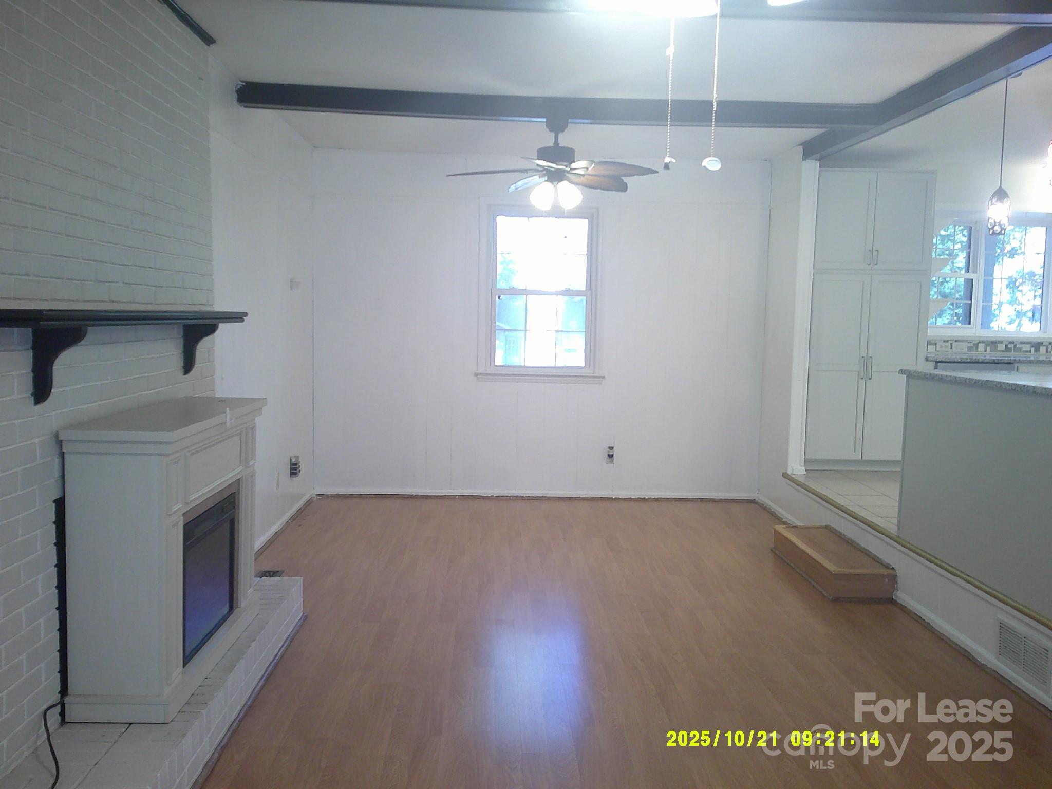 1820 12th Street Northeast Hickory, NC 28601 - Photo 10 of 20 an empty room with wooden floor ceiling fan and windows