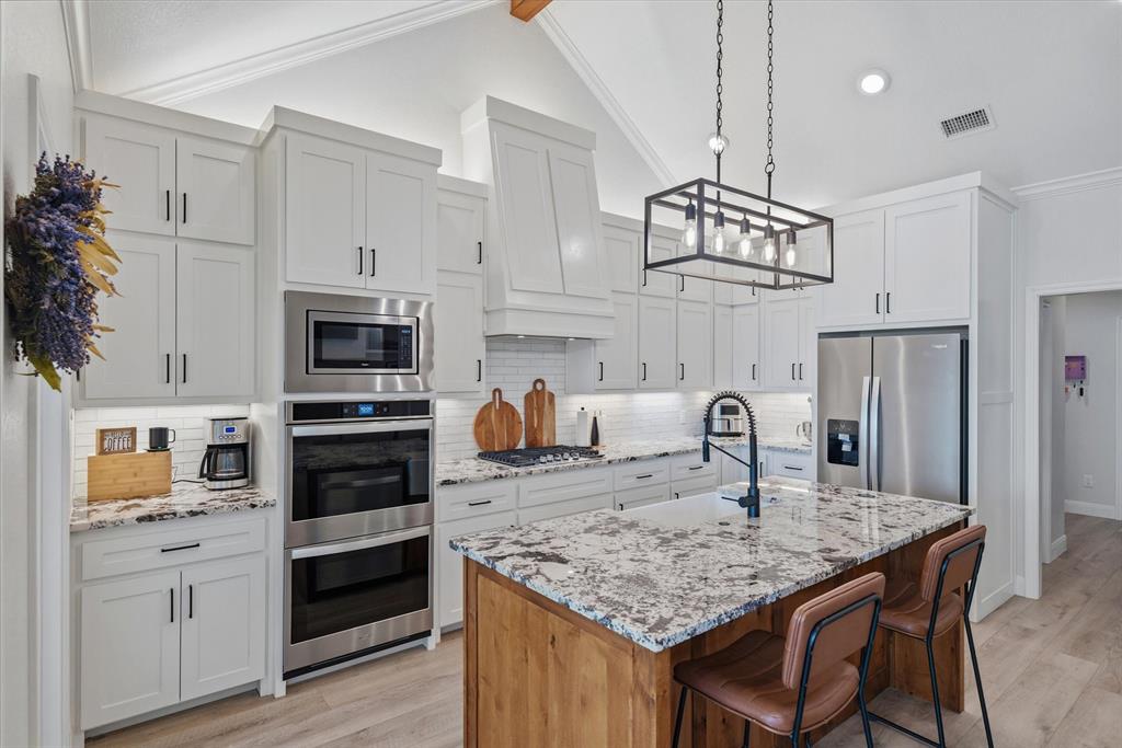 1825 Meadowview Canton, TX 75103 - Photo 18 of 36 a kitchen with kitchen island granite countertop a sink cabinets stainless steel appliances and a counter top