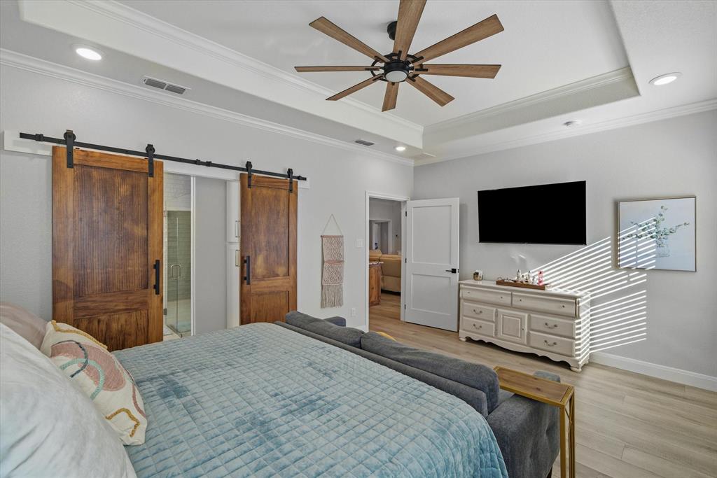 1825 Meadowview Canton, TX 75103 - Photo 23 of 36 a bedroom with a bed television on dresser and a chandelier