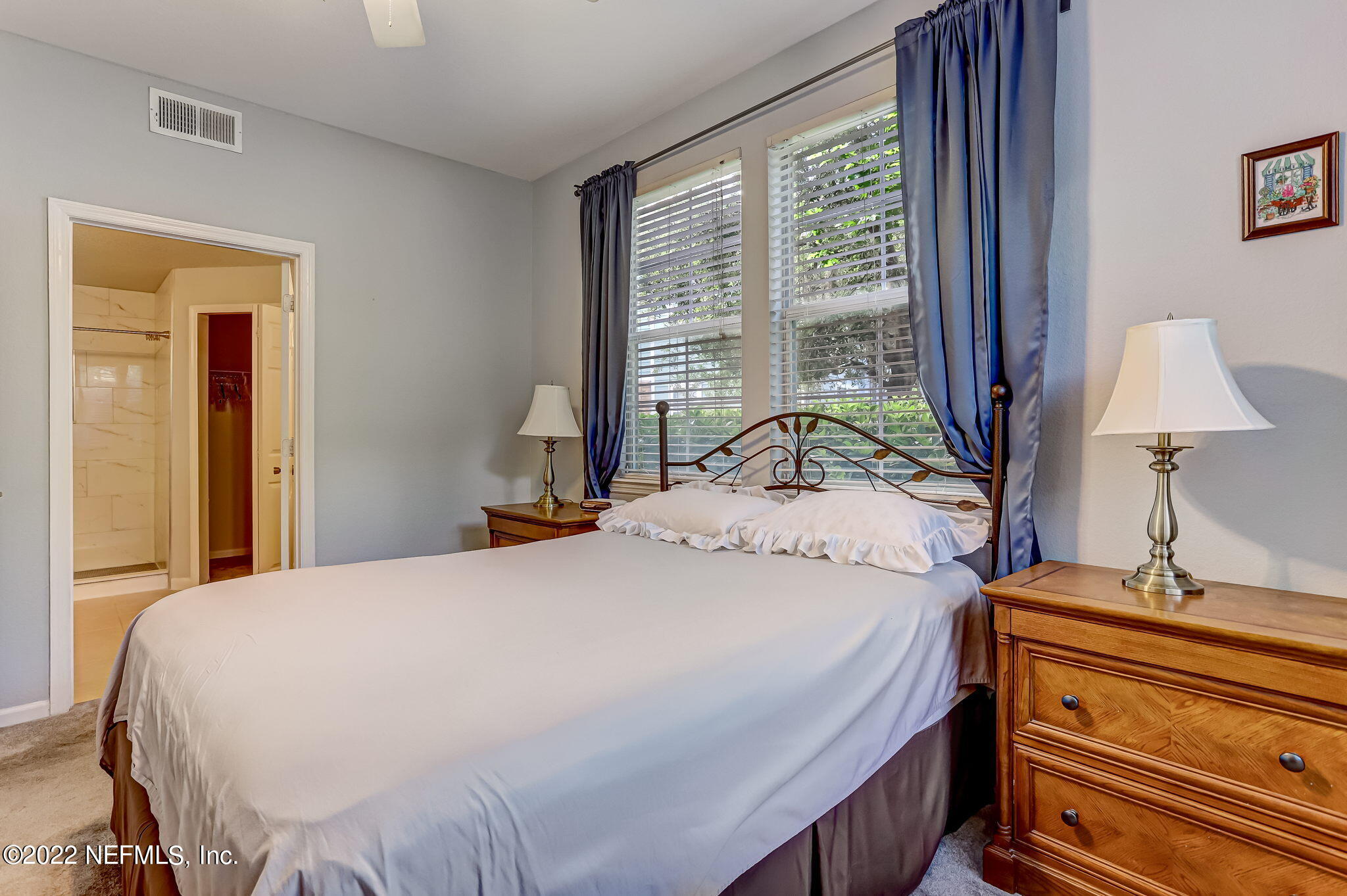 8550 Touchton Road, Unit 1117 Jacksonville, FL 32216 - Photo 21 of 61 a bedroom with a bed and a lamp on dresser