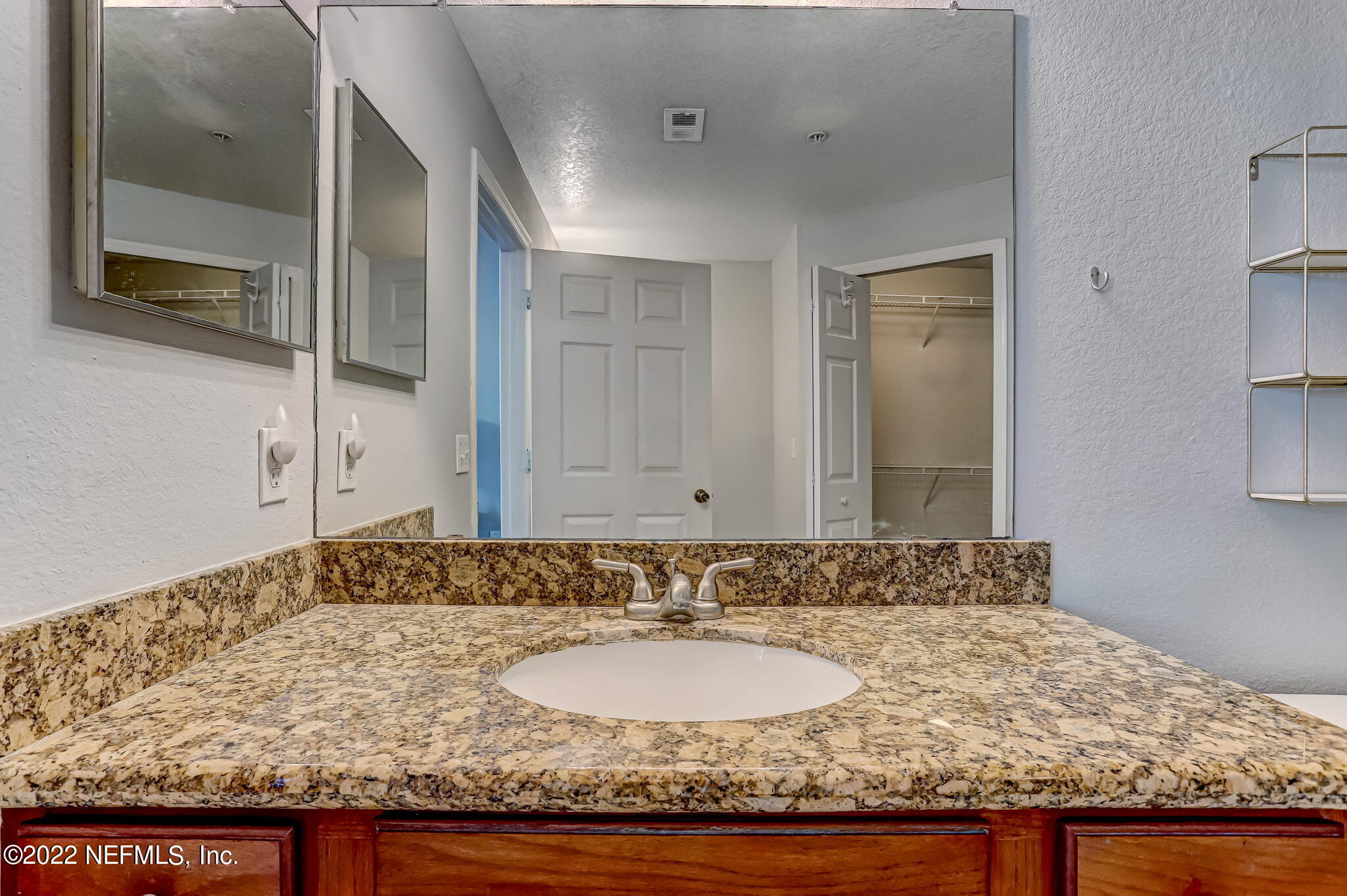 8550 Touchton Road, Unit 1117 Jacksonville, FL 32216 - Photo 26 of 61 a bathroom with a granite countertop sink and a mirror