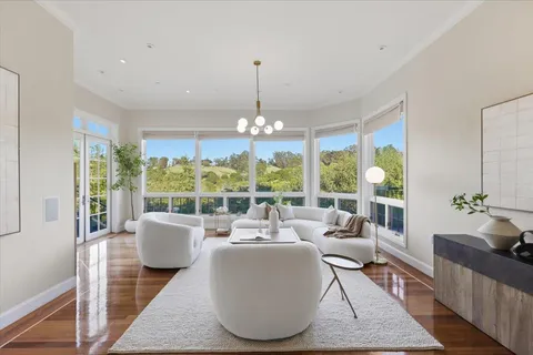 a living room with stainless steel appliances granite countertop furniture and a large window