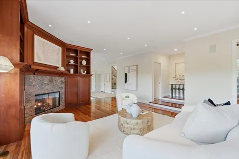 a living room with furniture a flat screen tv and kitchen view