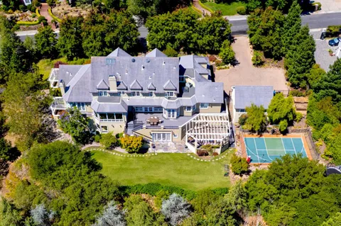 an aerial view of a house with garden space and street view