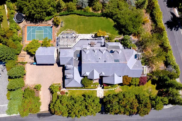 an aerial view of a house with a garden and lake view