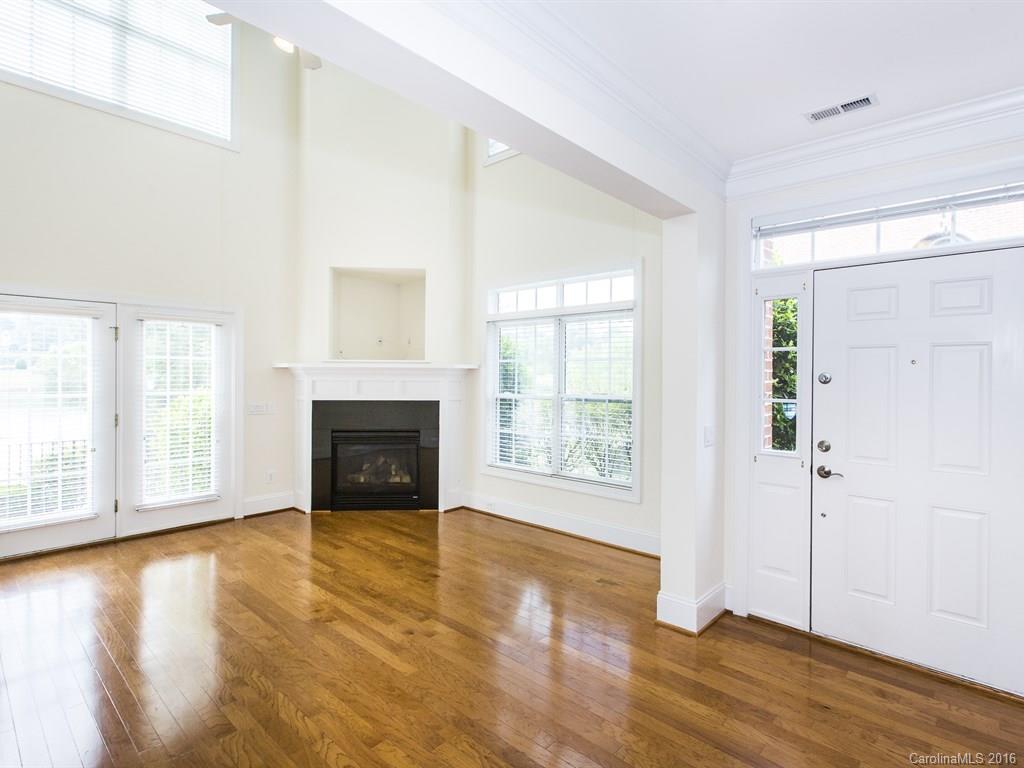 609 Crosswater Lane Fort Mill, SC 29708 - Photo 2 of 24 an empty room with wooden floor fireplace and windows
