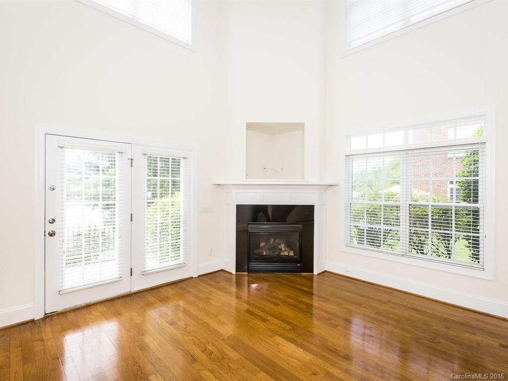 609 Crosswater Lane Fort Mill, SC 29708 - Photo 3 of 24 an empty room with wooden floor fireplace and windows