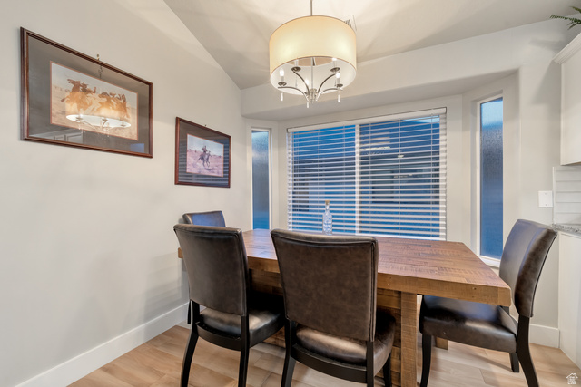 Undisclosed Address Ogden, UT 84403 - Photo 12 of 21 Dining room featuring light wood finished floors, vaulted ceiling, and a chandelier