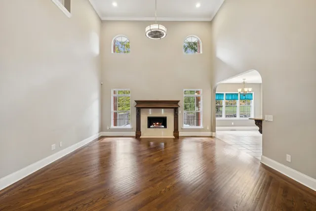 a view of an empty room with wooden floor and a fireplace