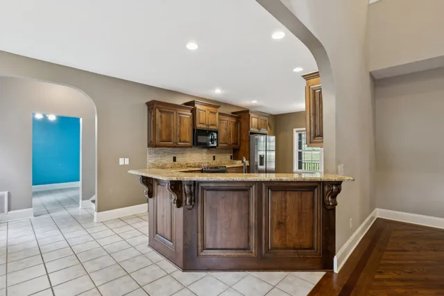 a kitchen with granite countertop a stove top oven cabinetry a sink and a window