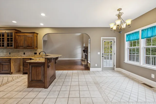 a view of an empty room with chandelier and window