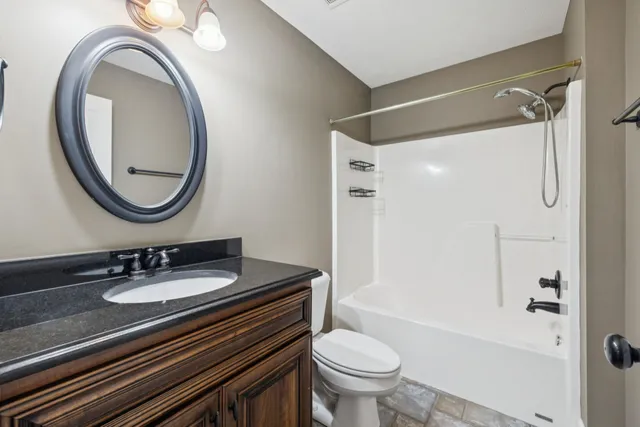 a backyard of a house with wooden fence and large trees