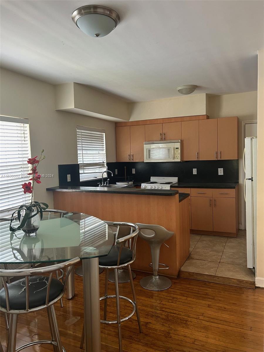 1241 13th Street, Unit 4 Miami Beach, FL 33139 - Photo 6 of 13 a kitchen with stainless steel appliances granite countertop a sink and cabinets