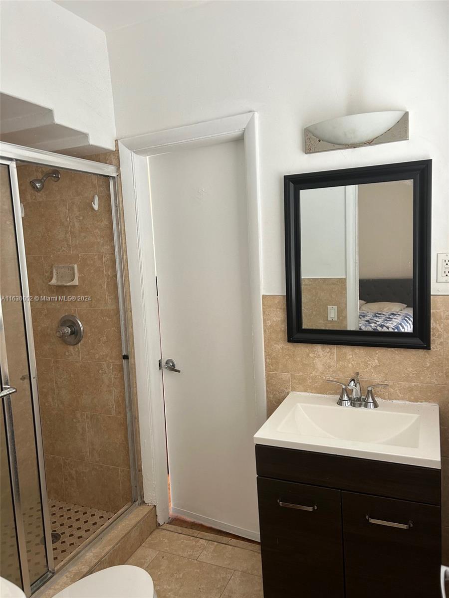 1241 13th Street, Unit 4 Miami Beach, FL 33139 - Photo 9 of 13 a bathroom with a sink mirror vanity and shower