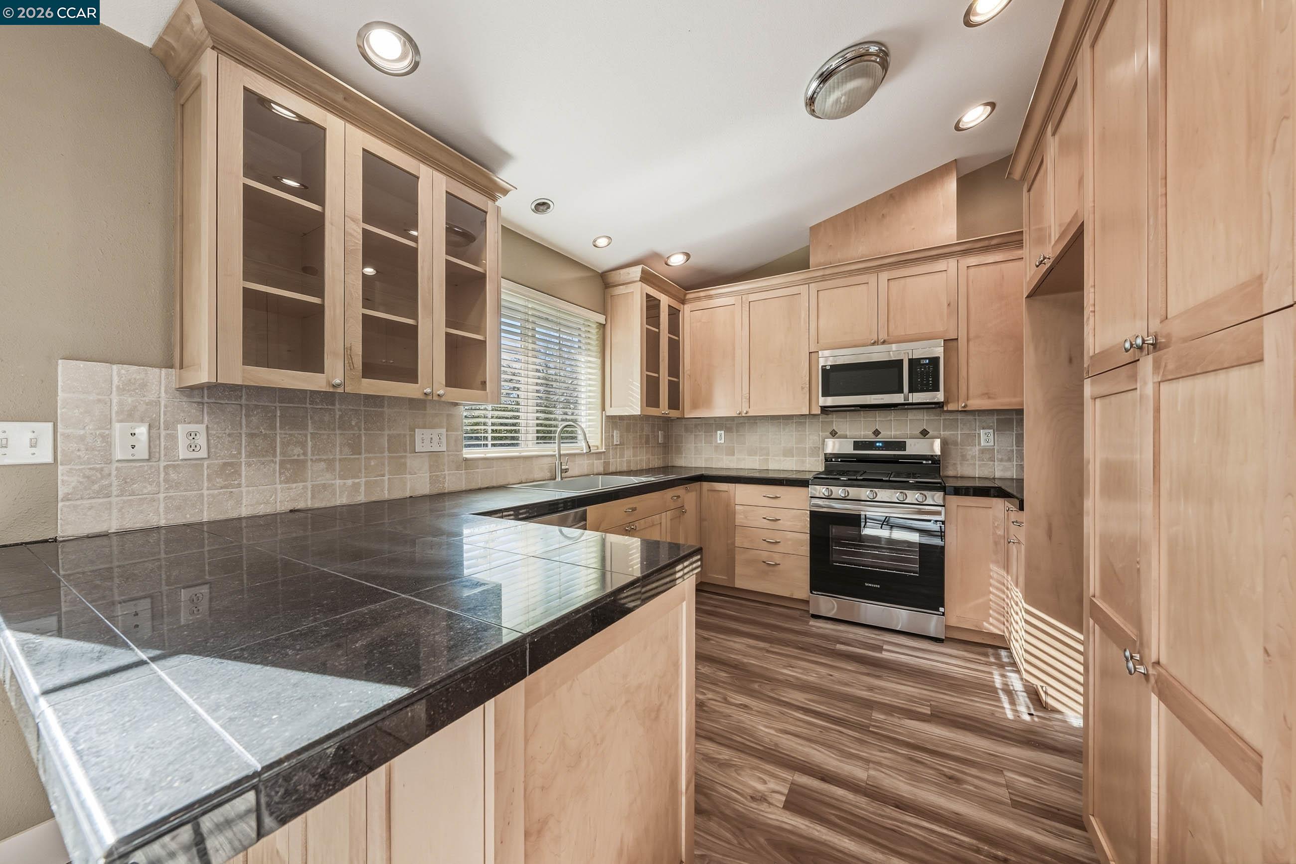 18357 Deer Hill Road Hidden Valley Lake, CA 95467 - Photo 16 of 29 a kitchen with stainless steel appliances a stove microwave and sink