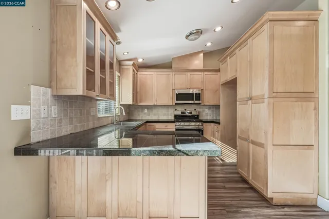 a kitchen with stainless steel appliances granite countertop a stove and a sink